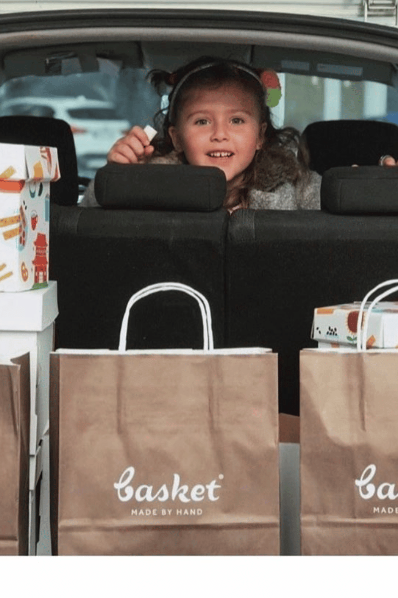 Devojčica i kesa sa Basket proizvodima. Zdravi integralni proizvodi bez aditiva, praktični za školu i svakodnevne aktivnosti