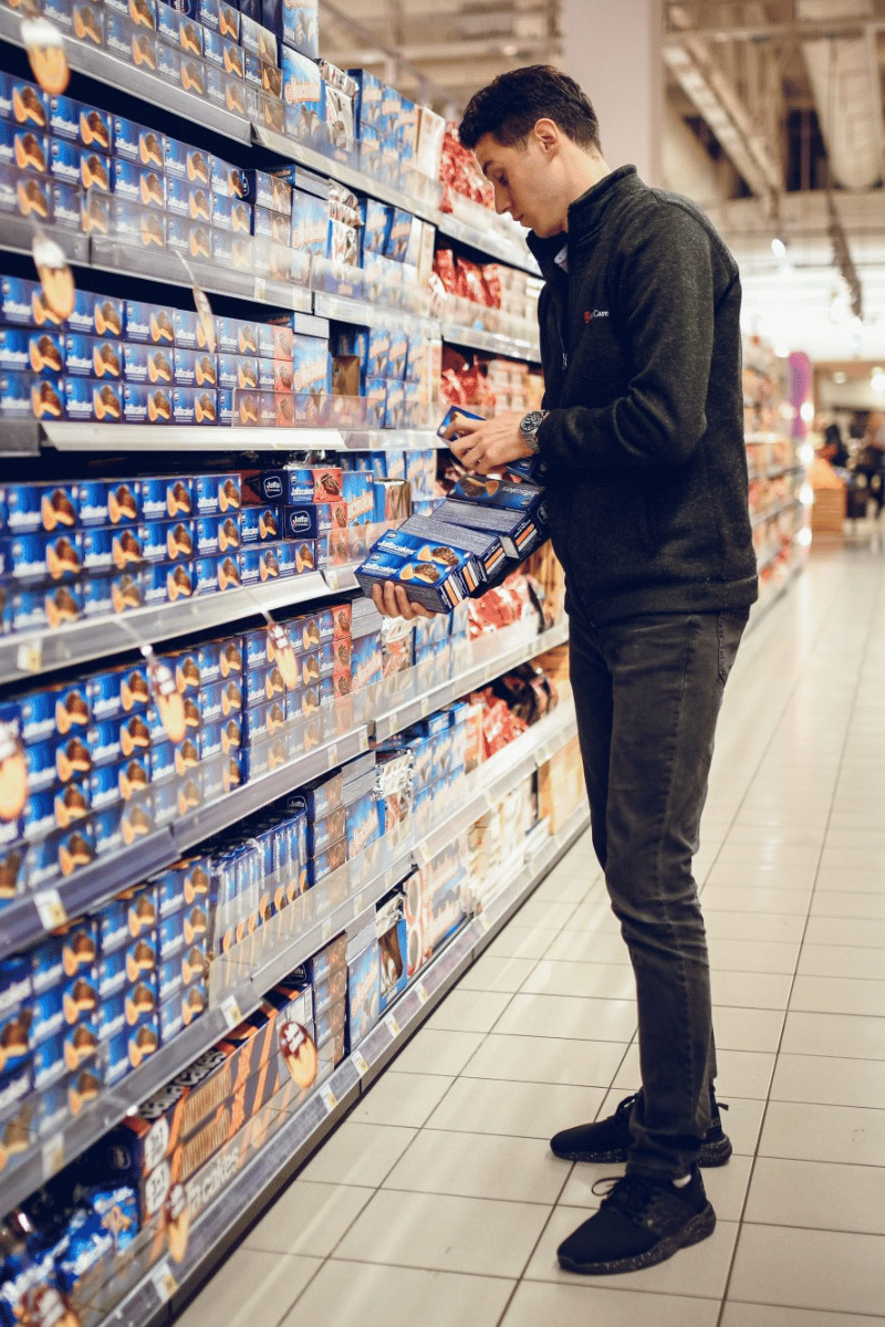 Merchandiser na terenu slaže proizvode na polici u supermarketu, primer operativne egzekucije u retailu